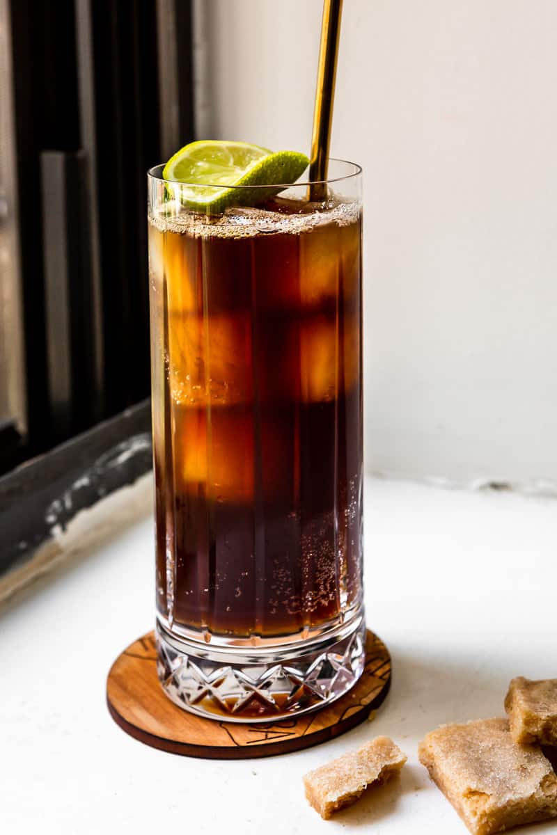 iced espresso tonic in a tall glass with ice, a straw and a lime wheel