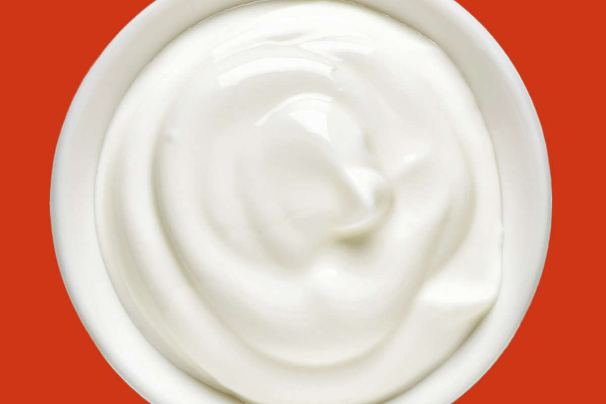 bowl of yogurt set on an orange background