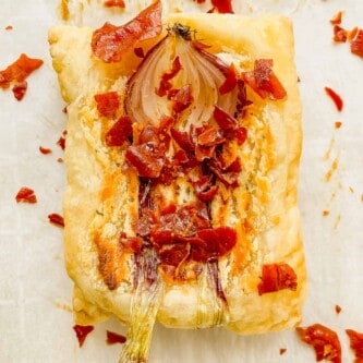 puff pastry tart with a roasted onion and crumble prosciutto over top
