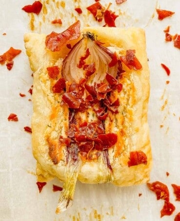 puff pastry tart with a roasted onion and crumble prosciutto over top