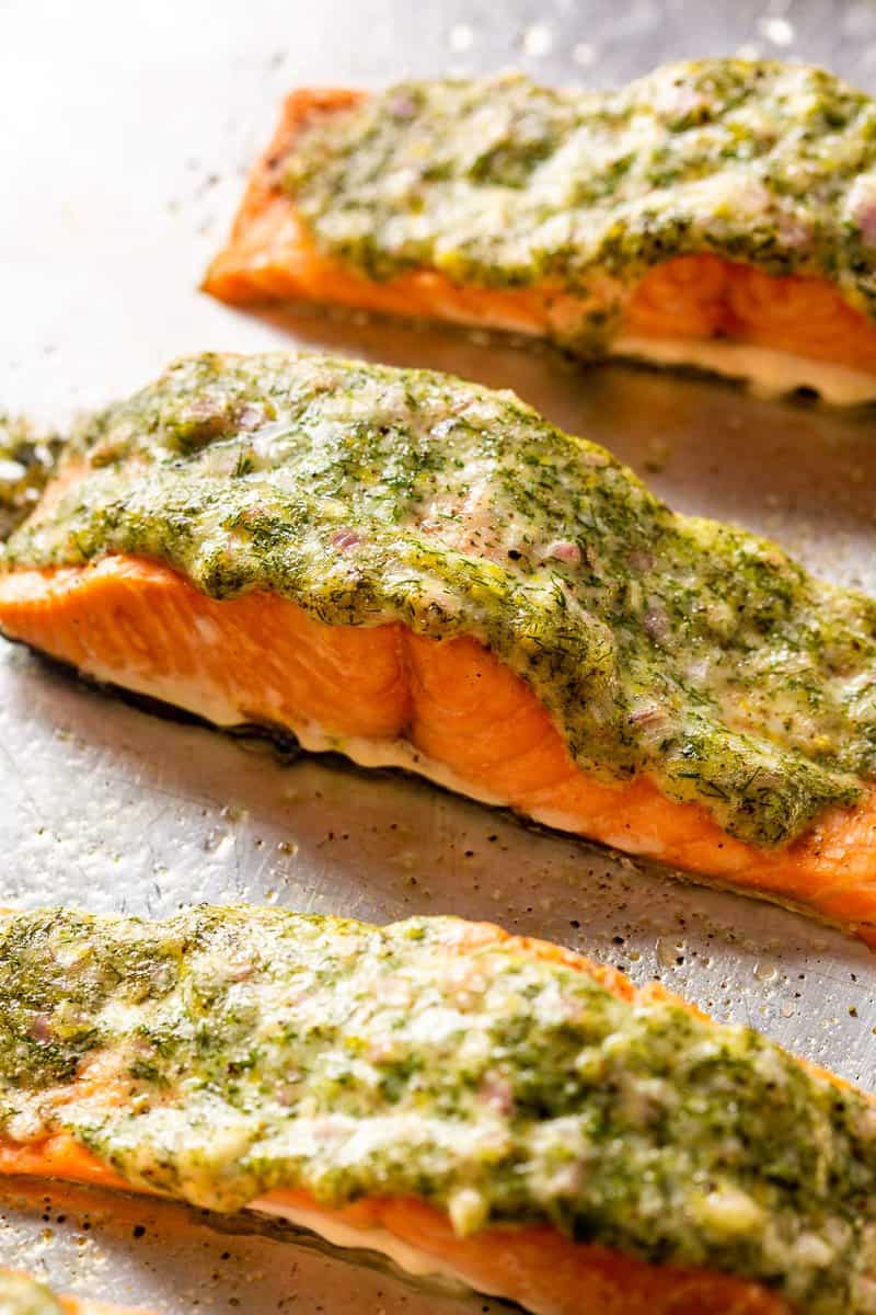 fillets of salmon on a baking sheet topped with dill and lemon mayo