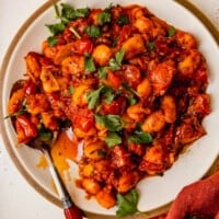 butter beans in a tomato sauce on a white plate