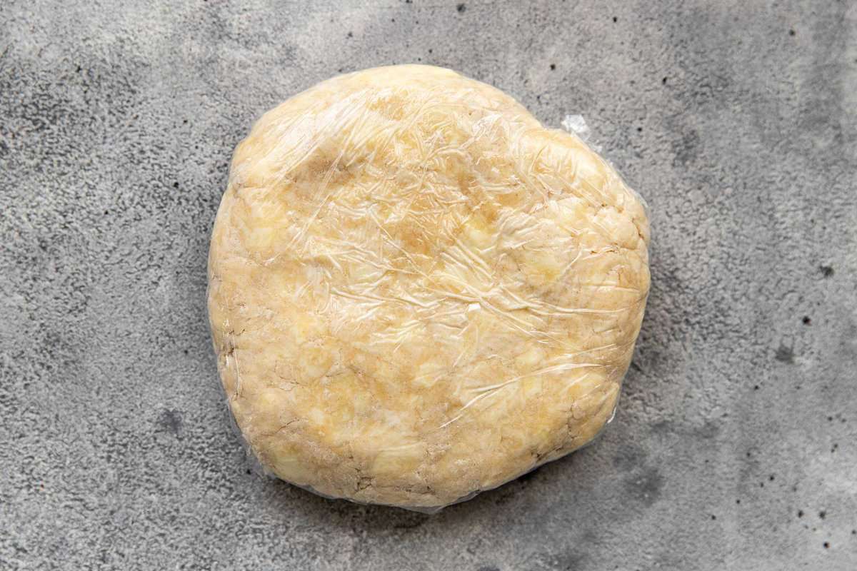 pie crust dough disk wrapped in plastic wrap.