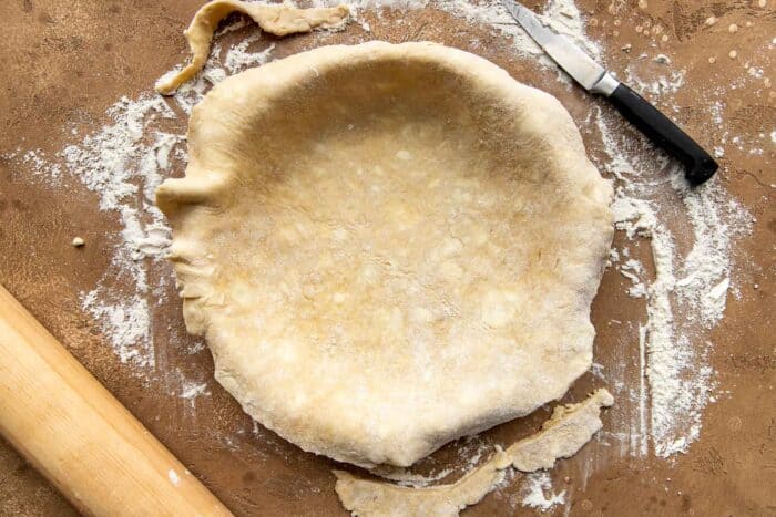 Pie crust draped inside a pie plate.