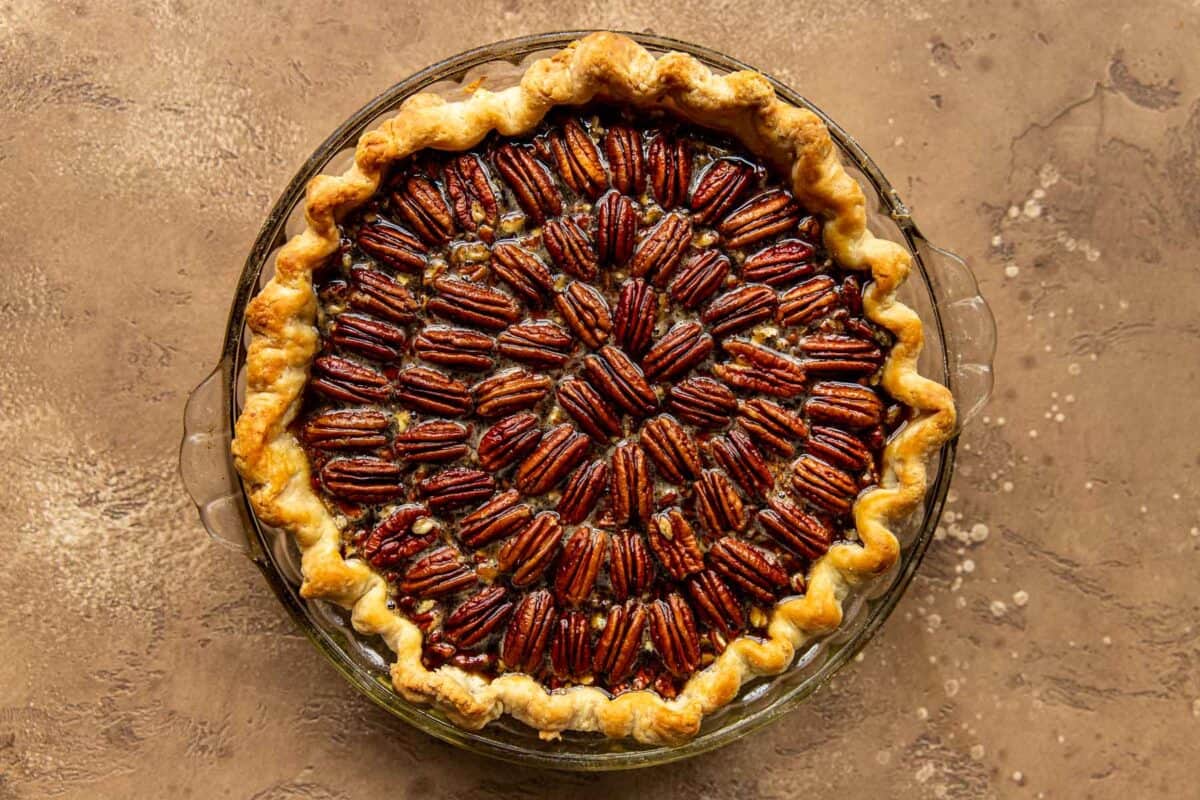 Unbaked pecan pie on a brown background.