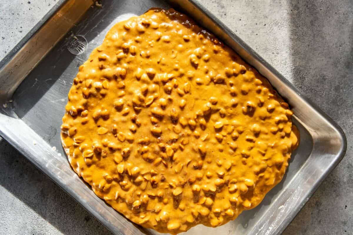 Peanut brittle right after being poured into a greased baking sheet.