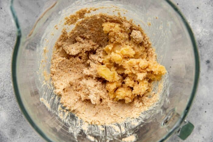 solidified browned butter added to a hazelnut and butter mixture in a mixing bowl. 