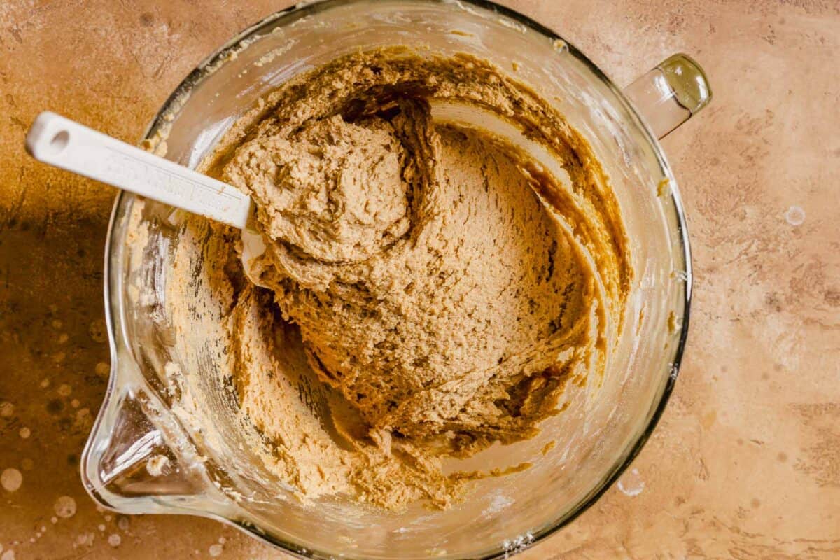 Peanut butter cookie dough in a glass mixing bowl.