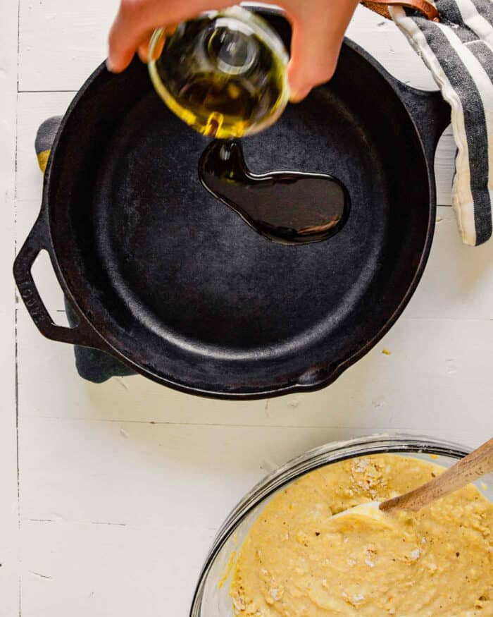 Oil being poured into a preheated skillet for skillet cornbread
