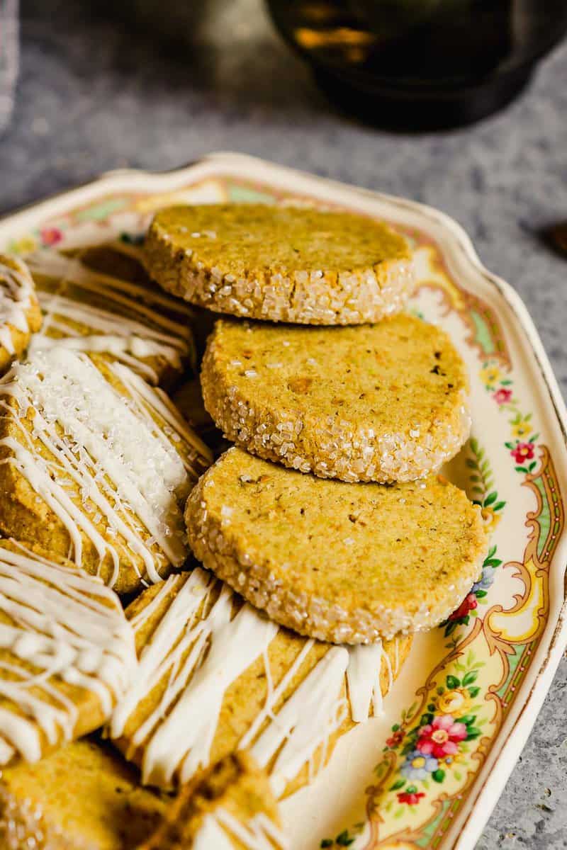 Pistachio shortbread with edges covered in sparkling sugar stacked on a platter.