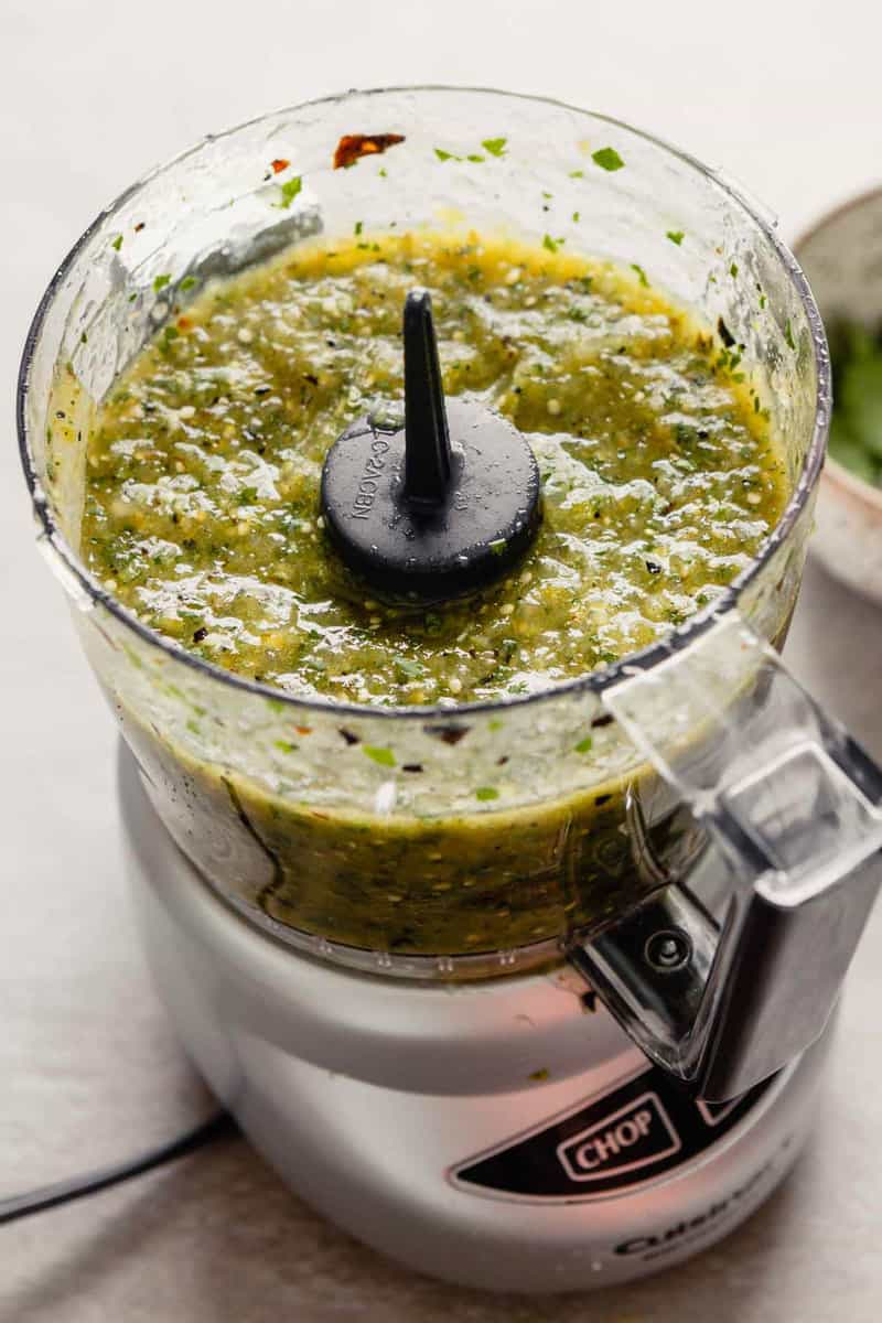 Homemade roasted tomatillo salsa in a food processor.