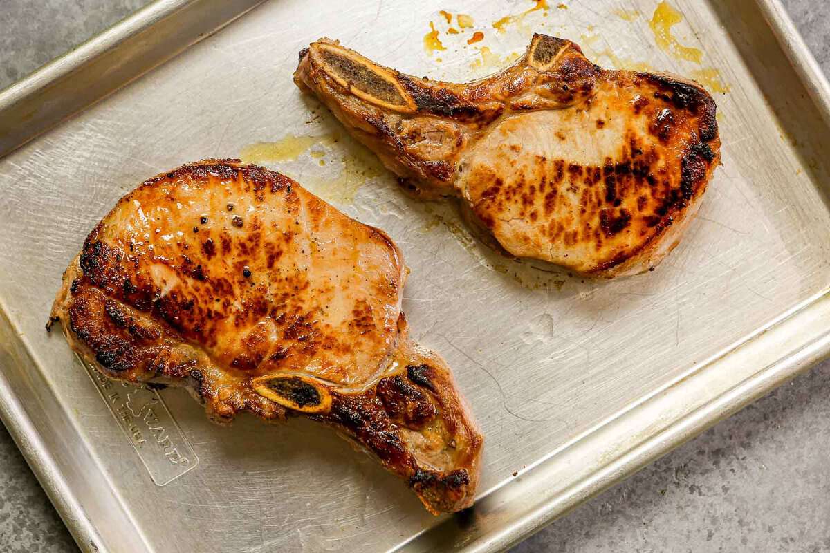 Pan-seared brined pork chops on a baking sheet.
