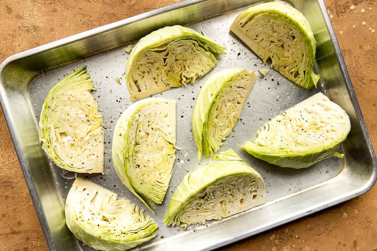 Cabbage wedges set on a baking sheet and brushed with oil, salt and pepper.