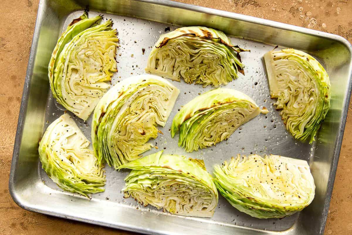 Roasted wedges of cabbage on a baking sheet.