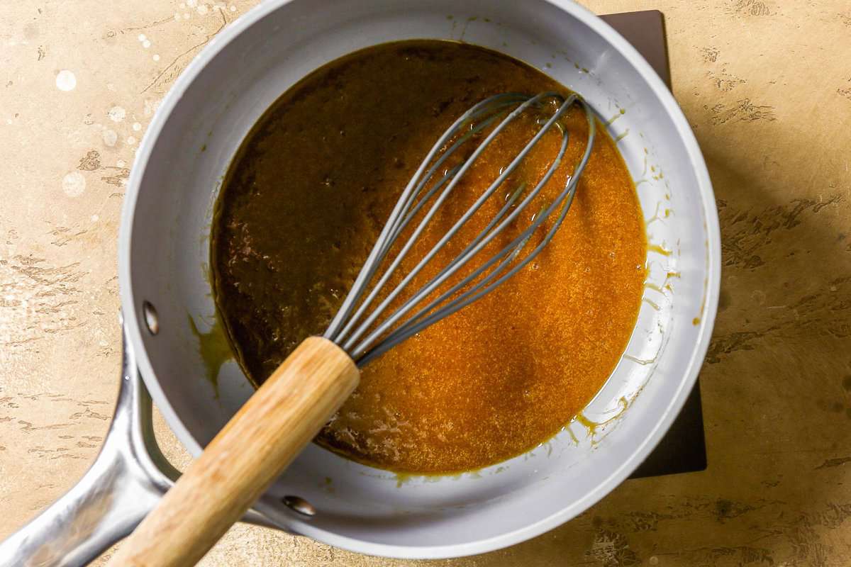 Caramel in a saucepan with a whisk set in it.