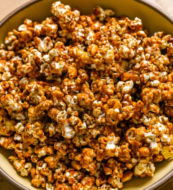 Spicy caramel popcorn in a large yellow serving bowl.