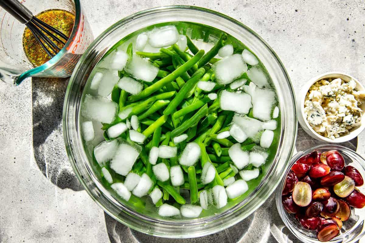 blanched green beans in a bowl of ice water.