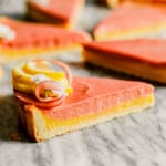 Slice of tart on a marble countertop with a layer of lemon filling and a layer of rhubarb filling.