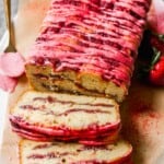 Strawberry pound cake with a strawberry drizzle set on a plate lined with parchment.