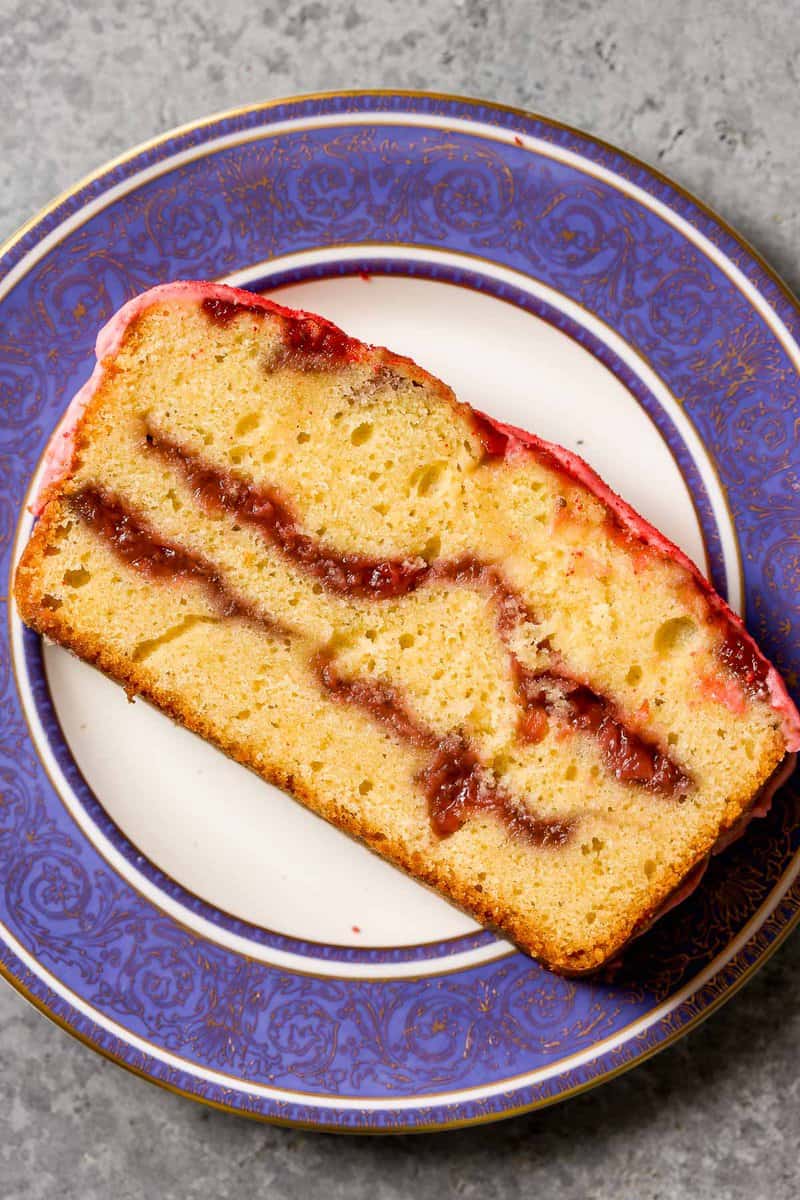 Slice of strawberry pound cake on a blue-rimmed plate. 