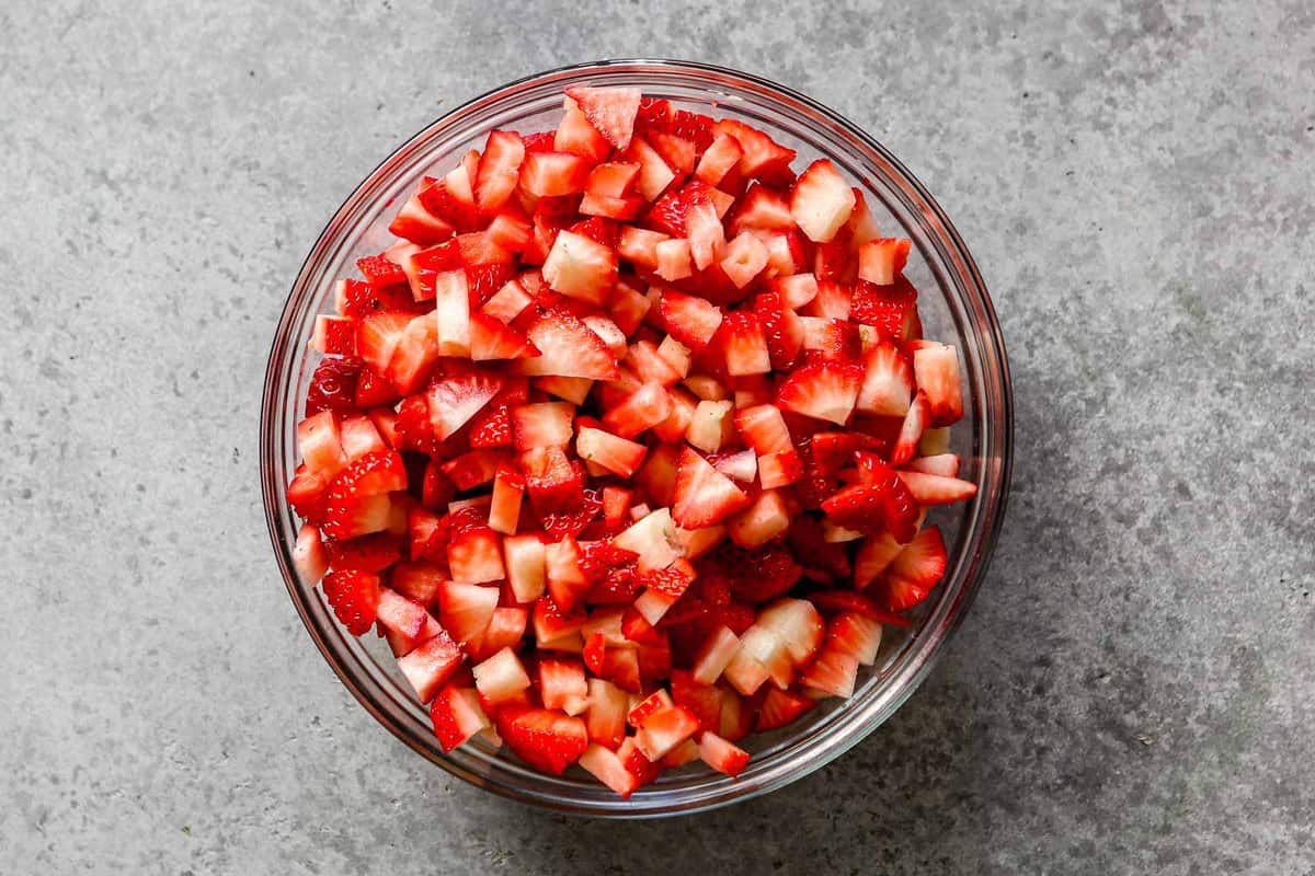 Finely diced strawberries in a glass mixing bowl.