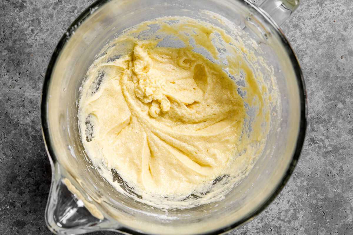 Butter, sugar and egg mixture in a glass mixing bowl.