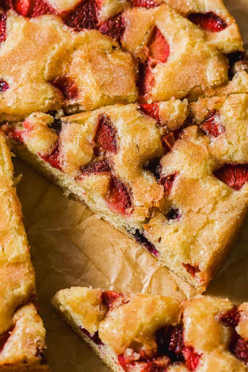 Slices of berry cake on a piece of parchment paper.