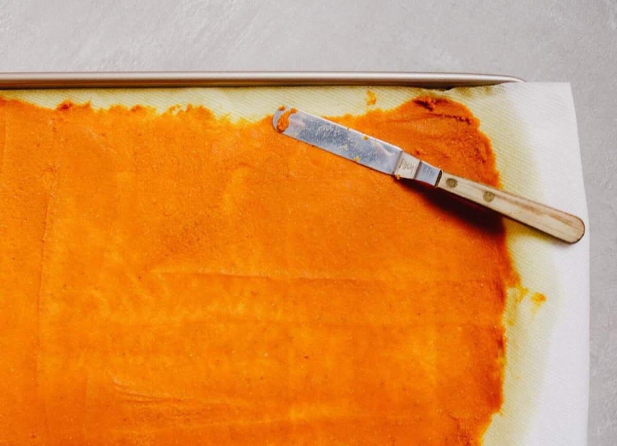 Pumpkin puree spread onto a baking sheet lined with paper towels