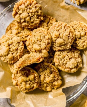 Pumpkin pie cookie set on a stack of pumpkin pie cookies with a bite taken out of the cookie.