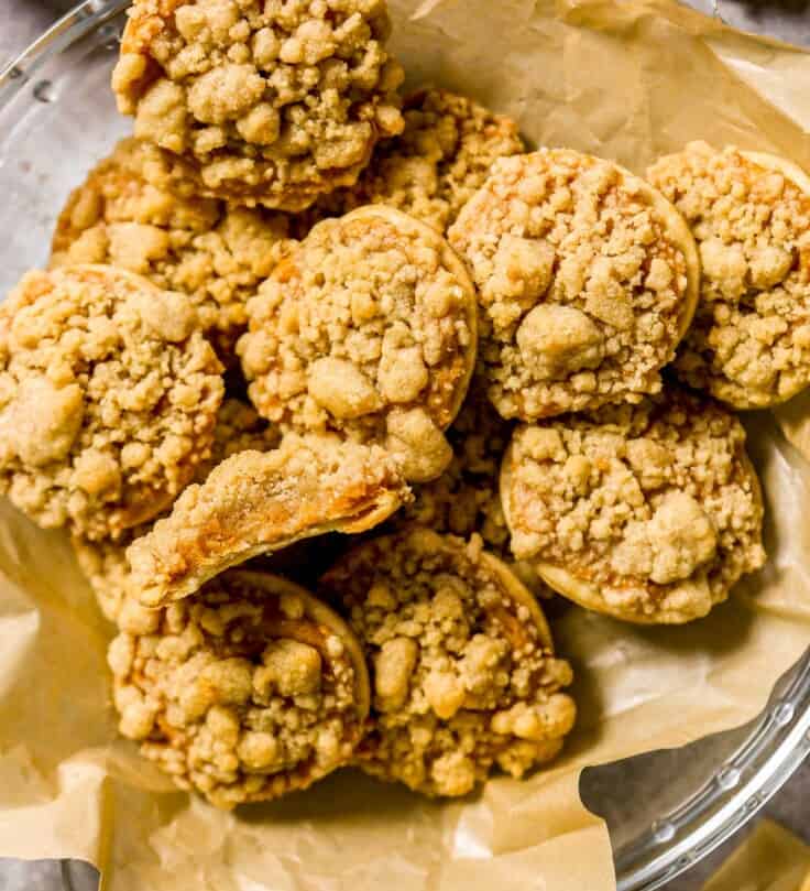 Pumpkin pie cookie set on a stack of pumpkin pie cookies with a bite taken out of the cookie.