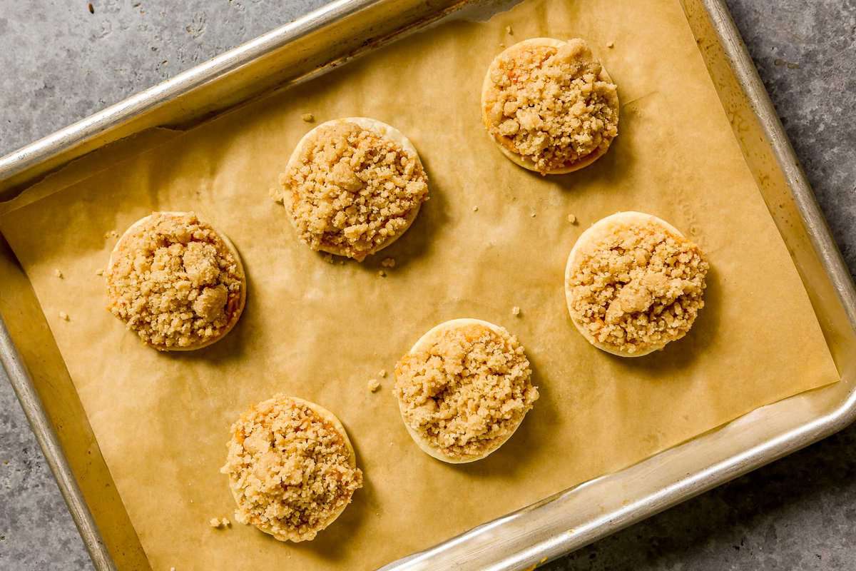 Streusel-topped cookies on a parchment-lined baking sheet.