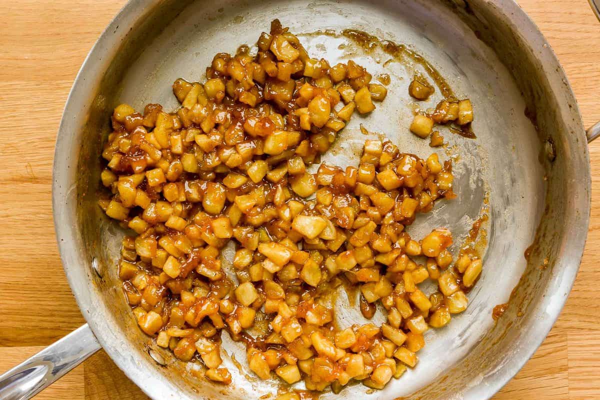 Finely diced apples cooked in a caramel-like sauce in a sauté pan.