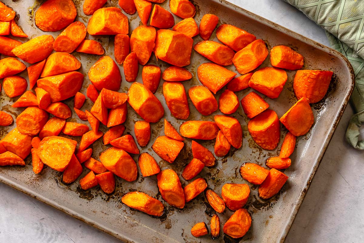 Roasted roll-cut carrots on a sheet pan.