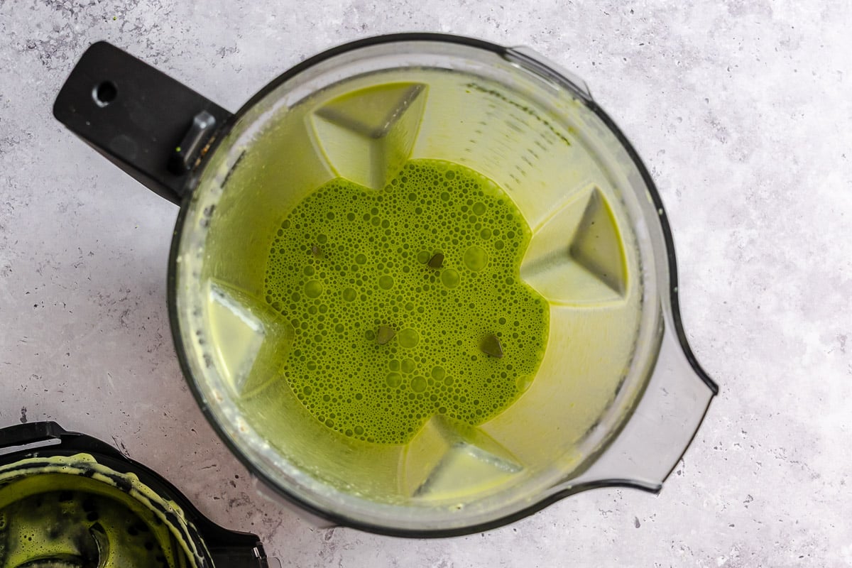 Creamy green coconut sauce in a blender.