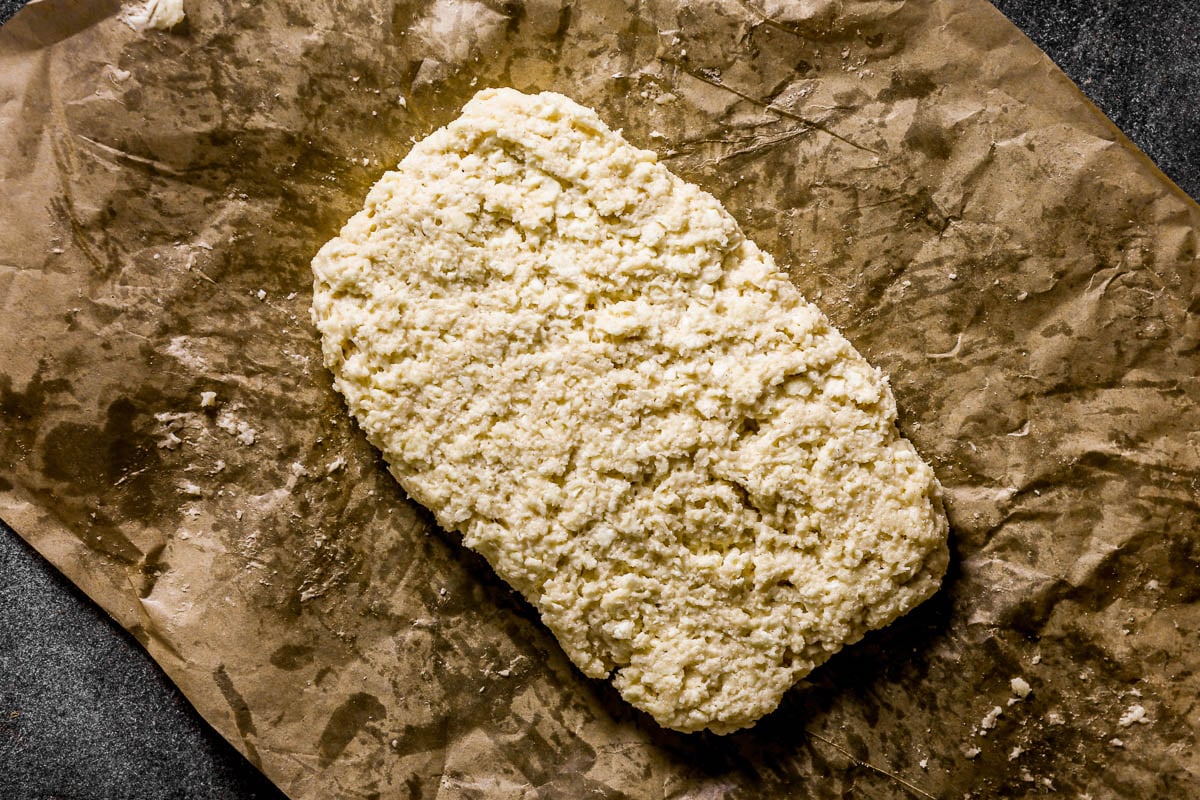 Scone dough on a piece of parchment paper.